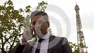 Businessman in a black suit speaks on a cell phone