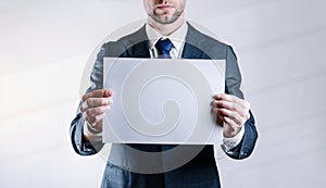 Businessman blank card. White blank board template holding business man on white background. Copy space empty poster.