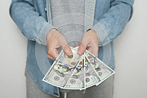 Businessman in blue shirt holds american dollars money on white background, closeup. Money, earnings, crediting and finance