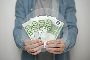 Businessman in blue shirt holds european euro money on white background, closeup. Money, earnings, crediting and finance