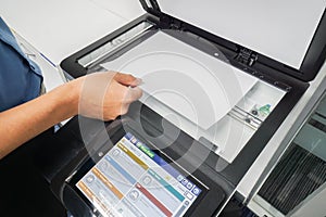 Businessman in blue shirt put paper sheet onto printer scanning