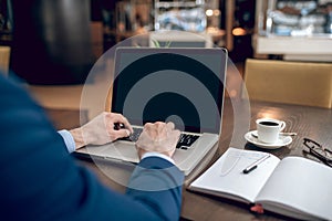 Businessman in a blue suit working on a laptop