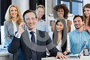 Businessman Boss Talking On Mobile Phone Call Over Mix Race Business People Group Standing Behind At Modern Office