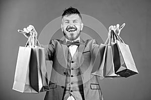 Businessman in bow tie. heavy bags. Mature shopaholic. stylish esthete with shopping bags. holiday purchase. business