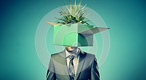 Businessman with box on head with aloe vera plant, Metaphor of diversity of Business economic and nature.