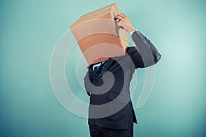 Businessman with box on head is confused