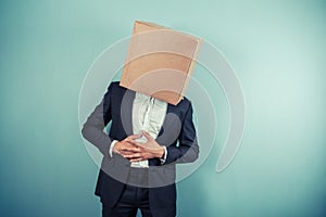 Businessman with box on head has stomach pains