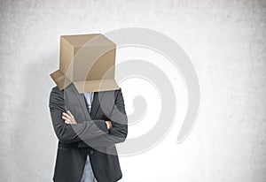 Businessman with a box on his head, concrete