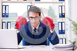 The businessman with boxing gloves angry in office
