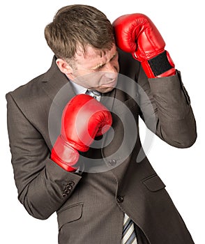 Businessman with boxing gloves defending