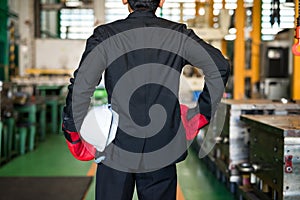 Businessman with boxing gloves and helmet in factory