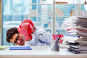 The businessman with boxing gloves in the office