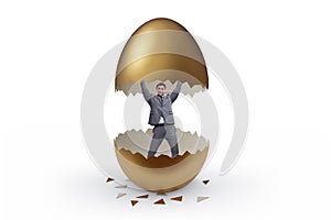Businessman breaking out of golden egg