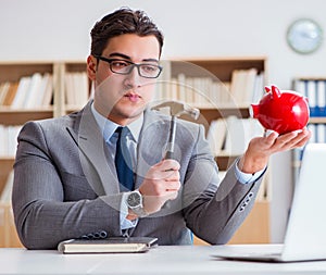 Businessman breaking piggybank in the office