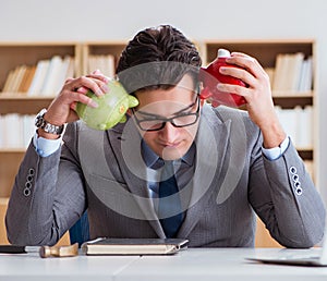 Businessman breaking piggybank in the office