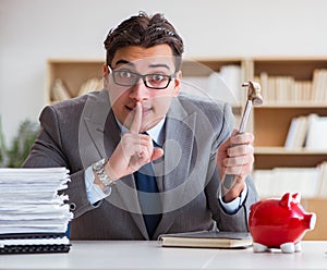 Businessman breaking piggybank in the office