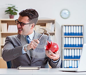 Businessman breaking piggybank in the office