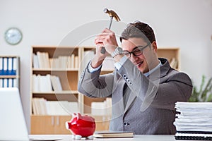 The businessman breaking piggybank in the office