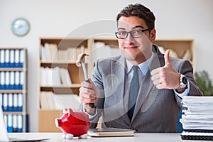 The businessman breaking piggybank in the office