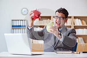 The businessman breaking piggybank in the office