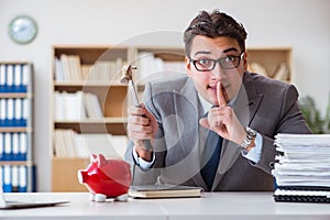 The businessman breaking piggybank in the office