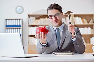 The businessman breaking piggybank in the office