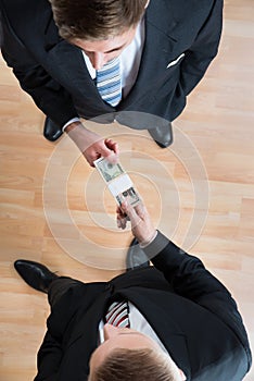 Businessman Bribing Colleague In Office