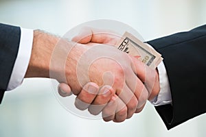 Businessman Bribing Partner While Shaking Hand