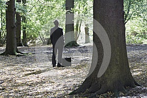 Businessman With Briefcase Standing In Forest