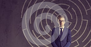 Businessman with briefcase standing on a labyrinth background. B