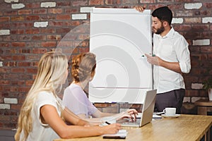 Businessman briefing over whiteboard to colleagues