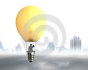 Businessman in brightly yellow lamp hot air balloon flying