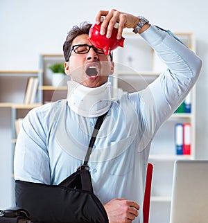 Businessman with broken arm working in office