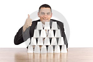 Businessman building cups' pyramid