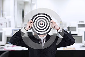 Businessman with bull's eye head at office