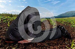 Businessman burying his head in the ground