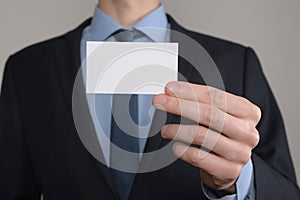 Businessman ,Business Man`s hand hold showing business card - close up shot on grey background. Show a blank piece of paper. Pape