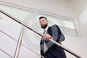 businessman in a business suit climbs the stairs to the top. Career growth concept.