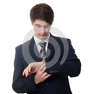 Businessman in a business suit looks at watch