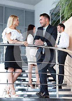 Businessman and business woman standing on the terrace of the office.