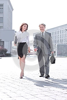 Businessman and business woman walking down the street