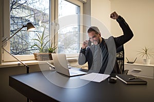 businessman businessman working on laptop in office taking notes making phone call satisfied with results on laptop in office