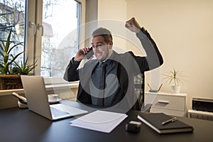 businessman businessman working on laptop in office taking notes making phone call satisfied with results on laptop in office