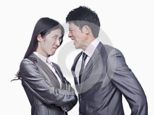 Businessman and businesswoman angry at each other, studio shot
