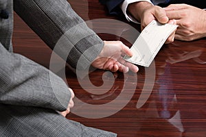 Businessman and businesswoman with blank cheque