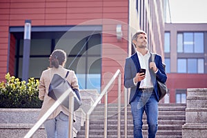 Businessman And Businesswoman Commuting Outdoors Passing On Steps On Way To Work