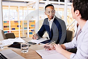 Businessman and businesswoman dicussing collaborative business in board room