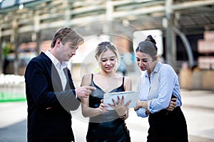 Businessman and businesswoman Discussing Over tablet While Standing Outdoors