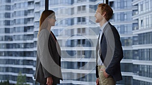 Businessman and businesswoman discussing plans. Executives shaking hands