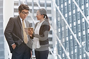 Businessman and Businesswoman Discussion with Tablet